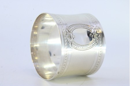 Argola de guardanapo em prata guilhochada envolvendo cartela para monograma e frisos perlados na envolvência.